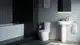 Badezimmeransicht mit dunklen Fliesen, freistehender Badewanne, wandmontiertem Waschbecken und WC. Ideal Standard Papierrollenhalter an der Wand.
